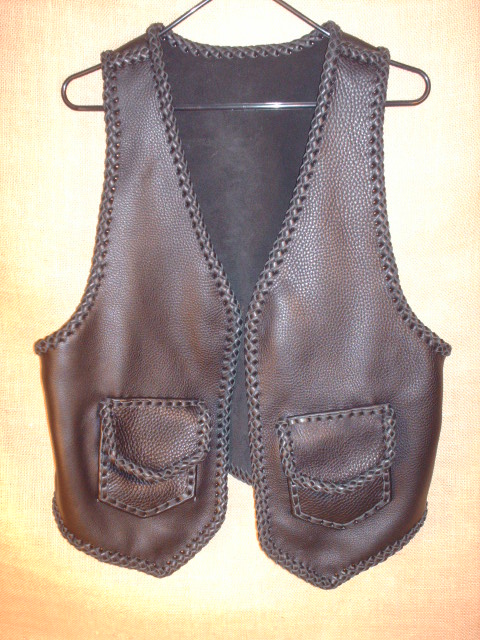  This braided moccasin cowhide leather vest has two front patch hip pockets with flaps ...which most always means that it also has two more matcing pockets on the inside using the same braiding to attach it - that's four pockets in total. 