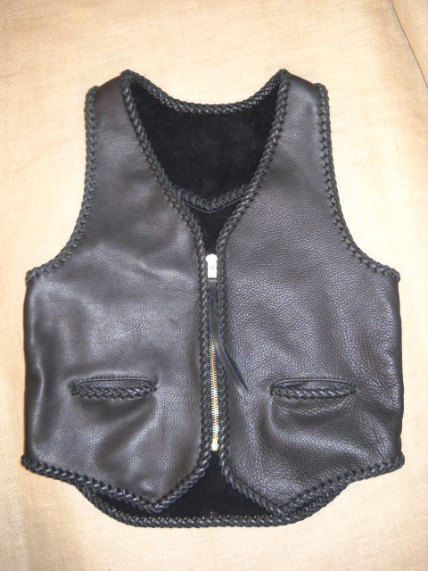  This black leather vest was built for a guy to use with his motorcycle. It features two hip slit pockets and a (YKK #10) brass zipper. It also has, what I call, a back draft flap ...which is a 3" extension of the bottom/back. 