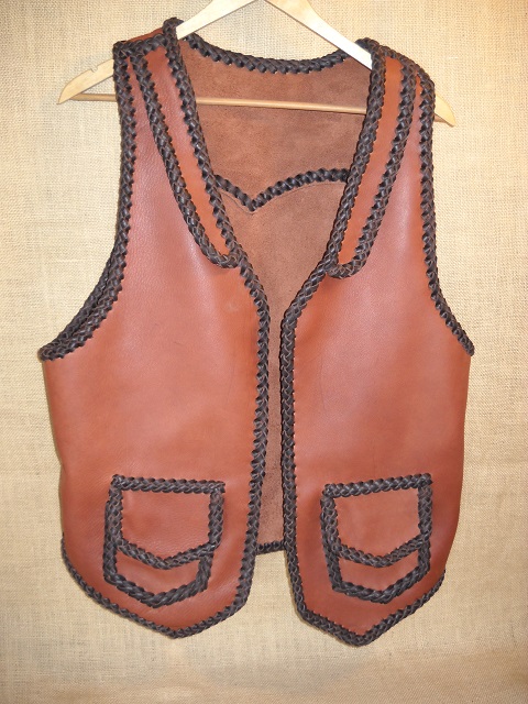  This two tone leather vest was built with moccasin cowhide. It has front lapels, a back pointed yoke, and two patch hip pockets with flaps. 