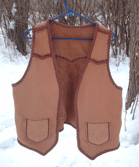  The buffalo (American bison) leather this vest was built with was provided by the buyer - the lacing for it is my moccasin cowhide leather. It has pointed yokes on the front and back, two patch hip pockets (without flaps) that also have matching inside pockets = four pockets in total. 