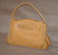  The back side of this purse has the braided oval slot to access the large back pocket that it has. 