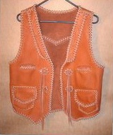  This Western style leather vest has front lapls, a back pointed yoke, two slit breast pockets, two patch hip pockets with flaps (with matching inside pockets without flaps), a back/bottom draft flap, and conchos that I fashioned for straps to hang from. Clicking on the link will bring you to more close up pictures of these features. 