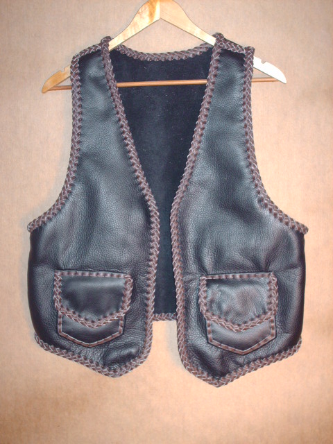  This two tone (black and brown) moccasin cowhide leather vest has patch hip pockets with flaps - these include inside pockets (without flaps). It's large arm hole built for wearing over a jacket. 