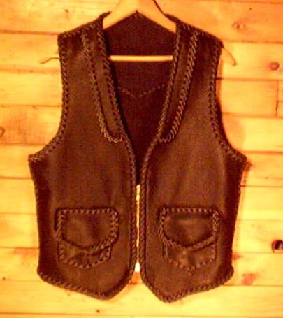  This black leather vest was hand braided and made in the USA using moccasin cowhide leather that is tanned in the USA. It has front lapels, a back pointed yoke, patch hip pockets with flapd (with matching inside pockets - No flaps. It also has a large brass, (YKK #10) zipper. Each vest that I construct is built to th details that the buyer has requested. 