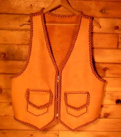  This two tone brown vest was built using moccasin cowhide leather that was tanned in the USA - it's also built in the USA. It has a large brass (YKK #10) zippr closure and two patch hip pockets with flaps. Those pockets also have similar inside pockets = four pockets in all. 