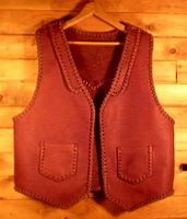  This custom built vest was made in the USA using moccasin cowhide leather that was tanned in the USA. It has lapels in front and a pointed yoke on the back. It's patch hip pockets are attached with a simple braid and these pockets also have matched pockets on the inside (four pockets in all). Click the linked picture for more about it. 
