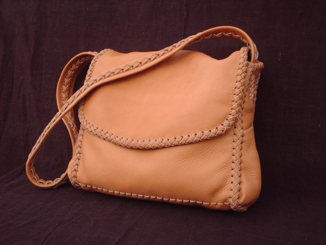  The dimensions of this large Chestnut colored moccasin cowhide leather bag are about 12.5" high x 11" high x 3". It has a full width pocket on the front under the flap, and a pocket on each side. It also has a large full width pocket on the inside/back. It is completely handmade - no electricity is used in it's construction.  