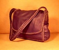  This dark Brown moccasin cowhide leather man bag is completely constructed with leather lacing/braiding. It is 100% leather - it has no hardware, no lining, nor thread. It has elaborately braided seams, as well as, around the flap, and down the length of its wide strap. The dimensions of it are about 14.5" wide by 12" high by 4".   It has four pockets - one full width on the front under the flap that is 9" high. There is another full width pocket on the inside back that is 9'5" high. It also has pockets on each sides that are about 4" wide by 6" high. 