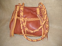  This Rust colored tote has two tone braiding (Rust and Chestnut). The seams of it are done with the more elaborate braid that folks often request, and, the straps are the more elaborate round braided ones. The braid dividing the front pockets of this tote is the actual 'stair step' side of the braid I've mentioned other totes having. Many of the other tote have the 'stair step' on the inside of the bag. 