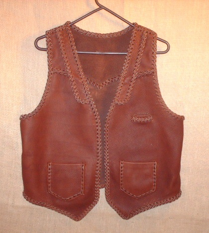  This brown moccasin cowhide leather vest has both lapels and slanted yokes on the front of it - that's what the buyer wanted. It also has a pointed back yoke, a single slit breast pocket (credit dard size), and two patch hip pockets (with matching inside pockets). 