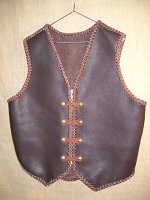  This two tone leather vest was built with moccasin cowhide. It has 4 sets of 'trick braided' snaps and a zipper for closures. It has no pockets. It does have the back/bottom draft flap that many folks like.  