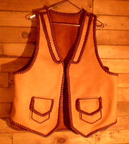  This two tone moccasin cowhide vest has front lapels, and two patch hip pockets with flaps. Patch pockets most always come with matching inside pockets using the same braiwork to attach - the inside pockets have no flaps. 