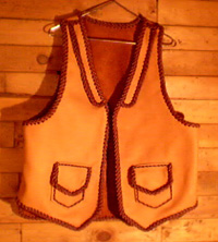  This two tone moccasin cowhide vest has front lapels, and two patch hip pockets with flaps - these patch pockets most always come with matching inside pockets using the same braidwork to attach - those inside pockets don't have flaps. 