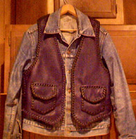  This braided leather vest was built so it could be worn over a jacket. It's seams, edges, and pockets (and their flaps) are also braided with 1/4" wide laces cut from the same leather that the vest parts are cut from. 