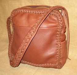  This messenger bag is a bit smaller than the other two shown here, and it's higher than it is wide (10" wide by 11" high by 4") The zipper extends over the sides and is about 14" long. 