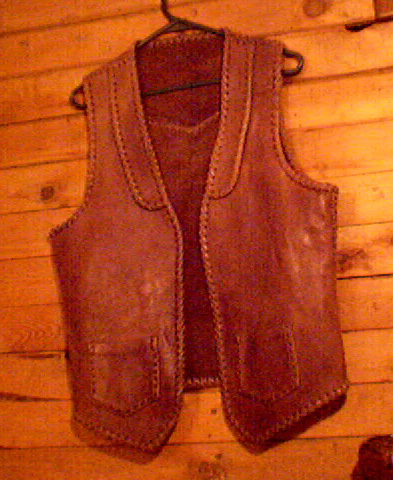 the front view of this quite old braided leather vest. The seams, edges, lapels, pockets, and back yoke are all constructed with leather braiding. 