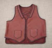  This two tone brown moccasin cowhide leather vest has front lapels, a back pointed yoke, and front patch hip pockets (without flaps). It also has two mated inside patch pockets attached with the same braiding as these outside ones. It has a 3" draft flap on the back/bottom of it. Clicking on this link will bring you to more text about it and more pictures of it. 